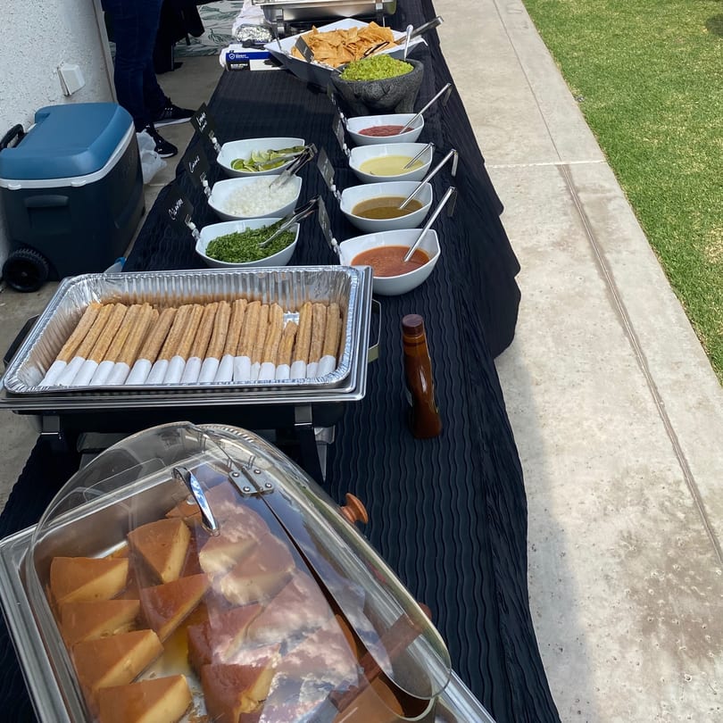 A Bandeño Mexican Food catering spread with chips, guacamole, salsas, churros, and flan.