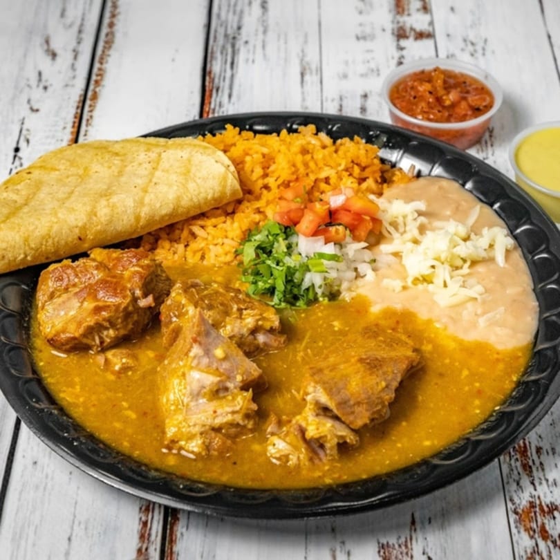 Bandeño Mexican Food plate with pork in green sauce, rice, beans, and a tortilla.