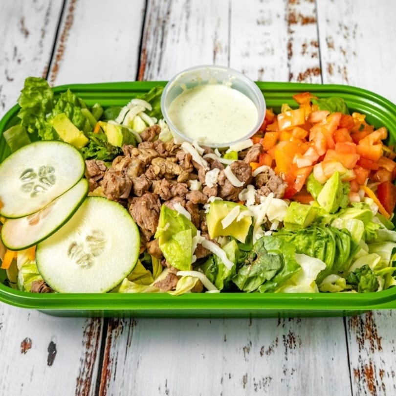 Bandeño Mexican Food's carne asada salad with lettuce, avocado, tomatoes, cucumbers, and dressing.