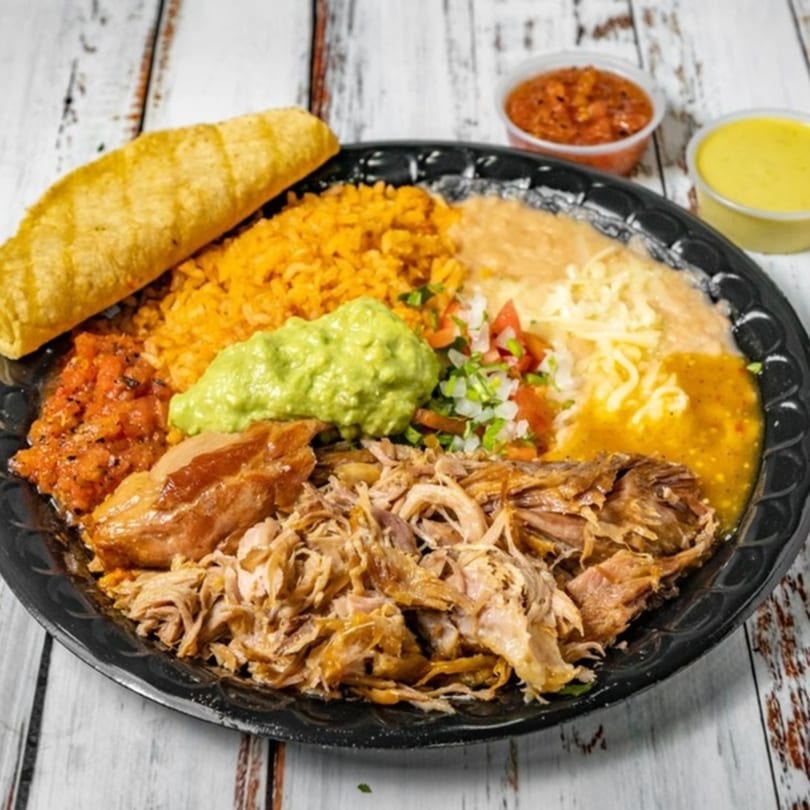 Bandeño Mexican Food's carnitas plate with rice, beans, guacamole, salsa, and a fried taco.